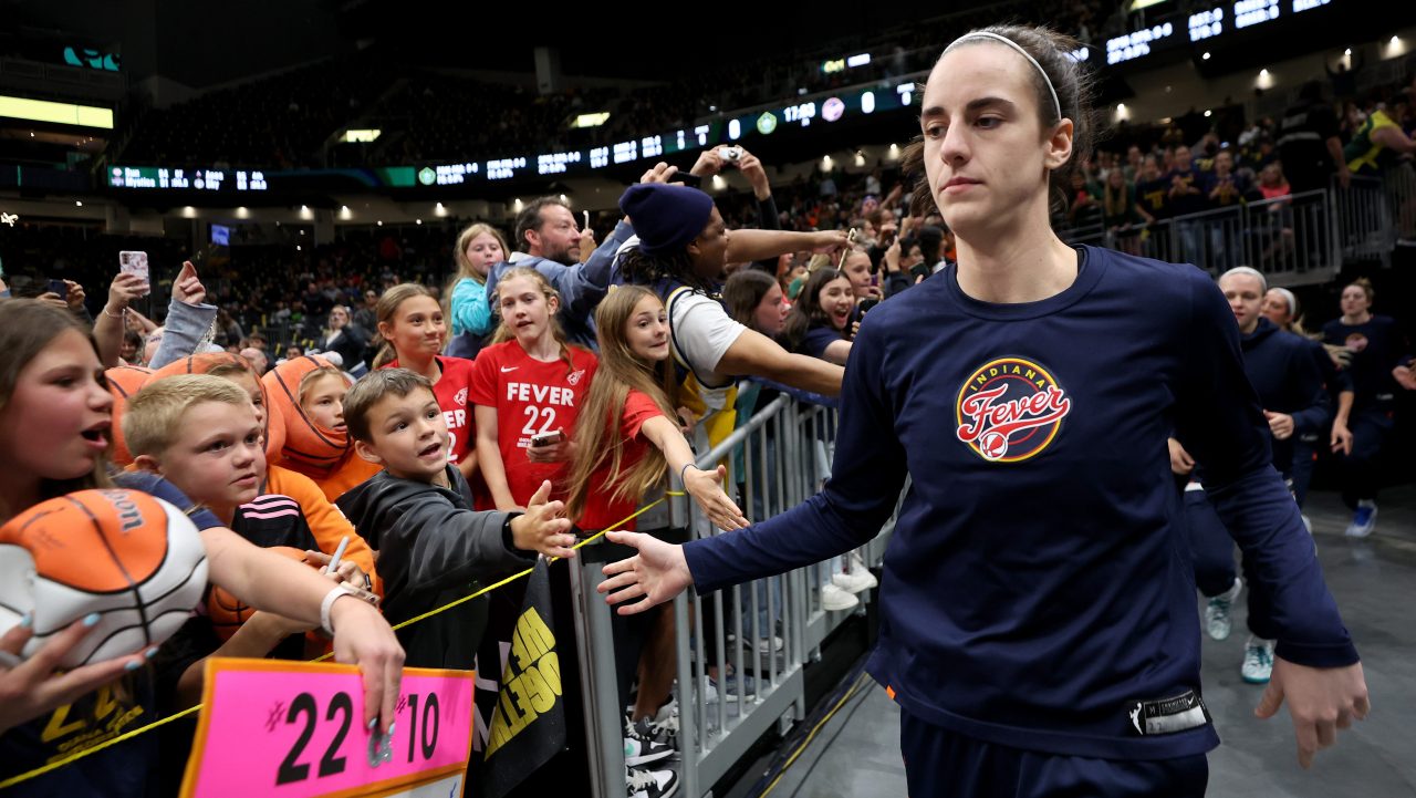 Caitlin Clark high fives fans at WNBA game